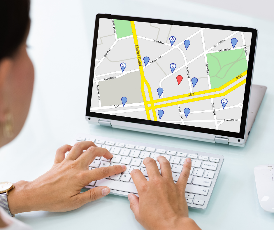 Woman typing on laptop with map on screen